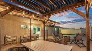 An outdoor patio with a wooden pergola, wicker furniture, and a pool. - Cozy Escape-Heated Pool-Perfect Location-SpringTRN (PHOENIX)