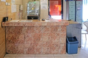 Ein Empfangsschalter mit Marmorplatte, ein Papierkorb und im Hintergrund eine Reihe von Schließfächern.