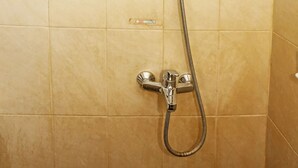 Eine Dusche mit Handbrause und fest installierter Duschköpfe.