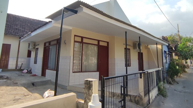 A residential house with a tiled roof, a covered porch, and a fenced yard. - Hotel O Khazanah Room Syariah (Yogyakarta)