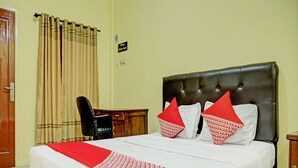 Ein Hotelzimmer mit Bett, Schreibtisch und Stuhl.
