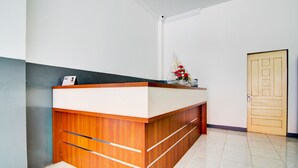 Una recepción con un calendario, un arreglo floral y una encimera de madera.