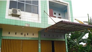 A two-story building with green and white walls, a covered entrance, and two motorcycles parked in front. - Hotel O Andesta Guest House SyariahNearAgrowisata Sungai Pinang Agro Nadin (Pekanbaru)
