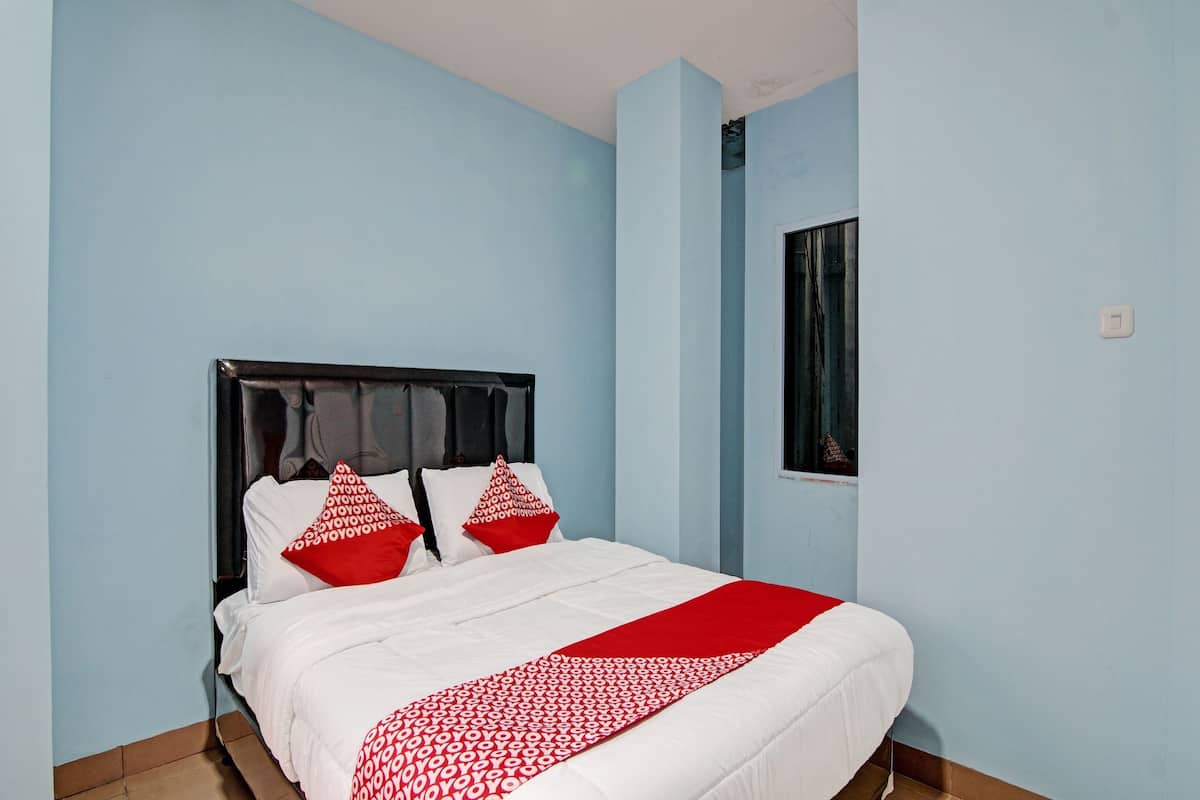 Una cama con ropa de cama blanca, almohadas rojas y una manta roja.