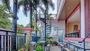 A multi-level outdoor patio with a spiral staircase, seating areas, and potted plants. - OYO 91951 Almira Homestay Syariah (Pekanbaru)