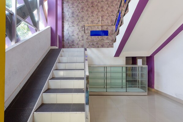 Una escalera con barandilla de vidrio que conduce a un nivel inferior con una división de vidrio.