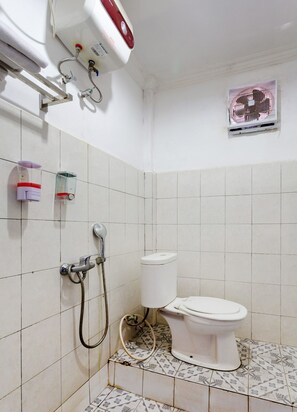 Un baño pequeño con inodoro, ducha y secador de manos.
