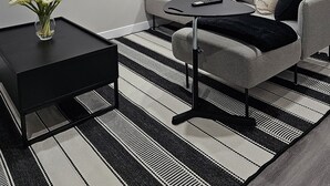 A modern living room with a grey sofa, black and white striped rug, and a black coffee table. - Cozy Suite: Private and peaceful 2 bedroom basement suite with keyless entry  (Edmonton)