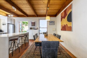 Enjoy meals and gatherings in this inviting kitchen and dining area with a long table and comfortable seating.
