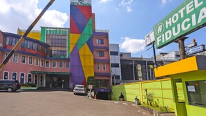 A hotel with a colorful facade and a prominent sign reading "HOTEL FIDUCIA". - Townhouse OAK Hotel Fiducia Pasar Minggu (Jakarta)