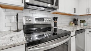A modern kitchen with a stainless steel stove, microwave, and dishwasher. - Urban Townhouse Near Downtown | 2BR + W/D (Columbus)