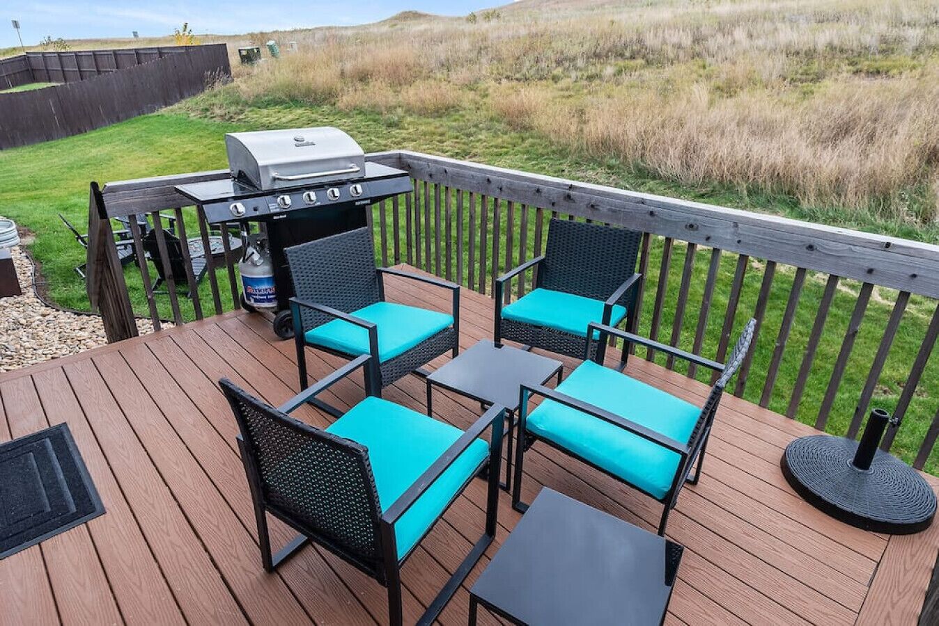 Une terrasse extérieure équipée d’un barbecue, d’un espace salon et offrant une vue sur le paysage environnant.