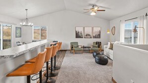 Een moderne keuken met een bar, zitplaatsen en kunstwerken aan de muur.