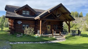 A log cabin with a porch, a stone pathway, and a grassy yard. - Tweek's Cabin- luxury cabin with yard, fire pit, and hot tub!!!

 (Cody)