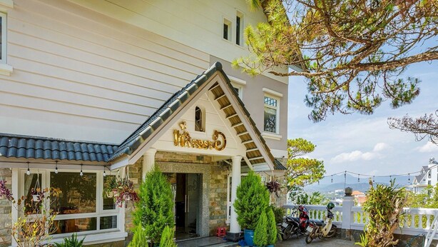 A hotel entrance with a stone facade, a wooden staircase, and potted plants. - Capital O 1207 Green Hill Villa Da Lat (Xuan Truong - Da Lat)
