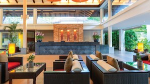 A spacious lobby with wicker furniture, a reception desk, and potted plants. - Homm Suites Laguna, part of Banyan Group (Choeng Thale)