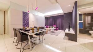A modern living room with a dining area, a sofa, and a small table.