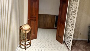 A hallway with a wooden door, a globe on a stand, and a patterned floor. - remodeled home-Montgomery,AL: Auburn, Tuskegee. Troy, and ASU -high schools (Montgomery)