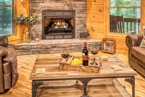 A cozy room with a stone fireplace, leather furniture, and a table with wine glasses and a bottle. - Cozy Bear Retreat - Game room, private, fire pit (Blairsville)