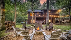 A cabin with a fire pit, outdoor seating, and a hammock.
