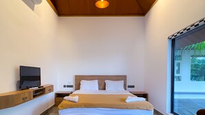 Ein modernes Hotelzimmer mit einem großen Bett, einem Fernseher auf einer Holzkonsole und Blick auf Grünflächen durch das Fenster.