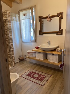 Chuveiro, bidê, toalhas de banho 