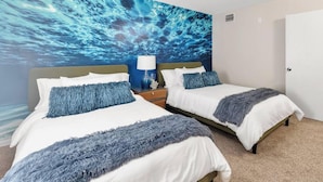 A hotel room with two beds, a large blue mural on the wall, a nightstand with a lamp, and a door. - 8 Bdrm Mansion 10 Mn To Honeymoon Island Beach (Palm Harbor)