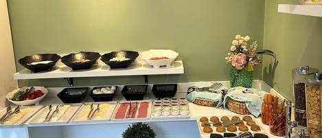A buffet setup with various food items and utensils.