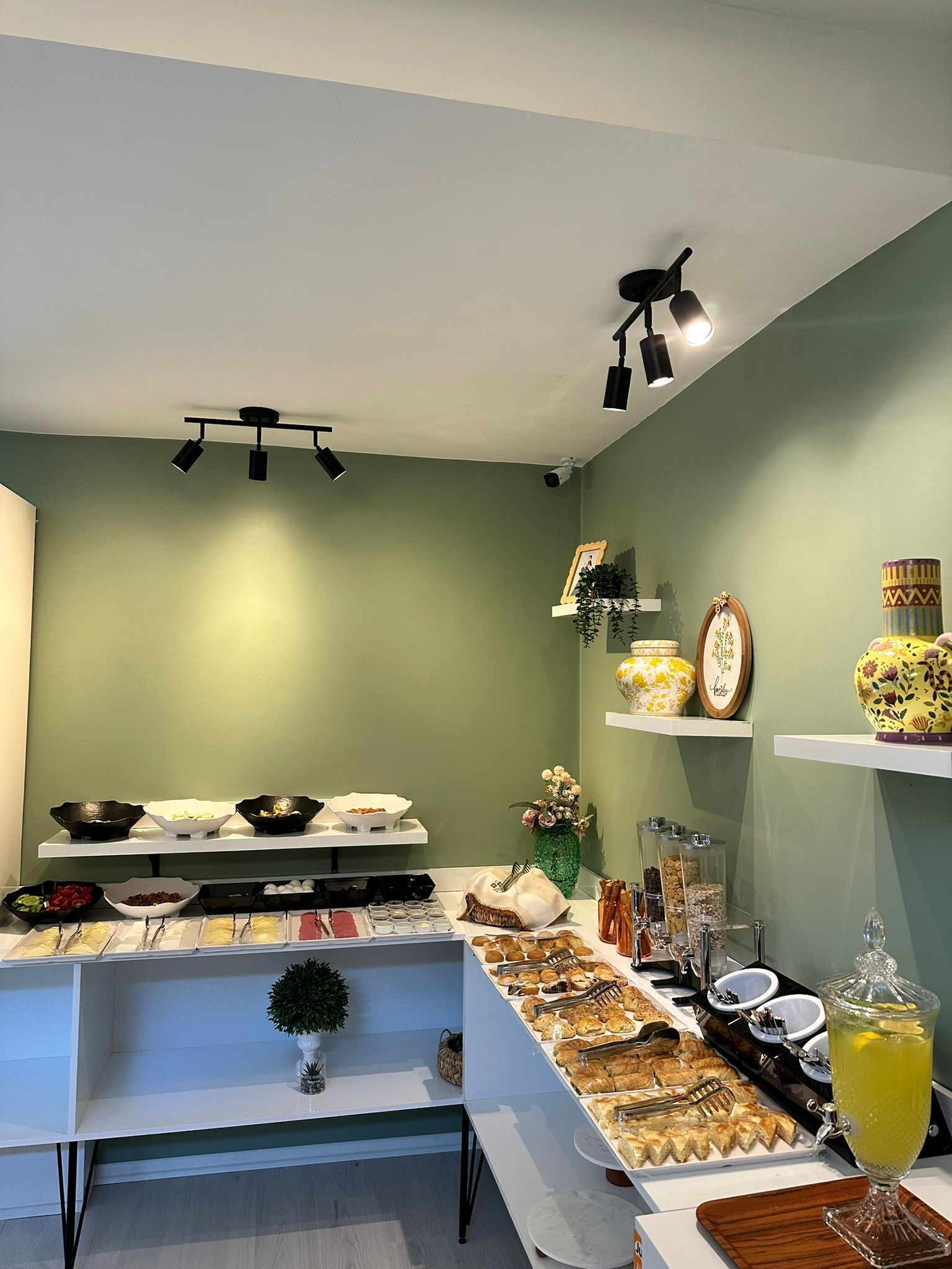 A buffet setup with various food items and a drink dispenser.