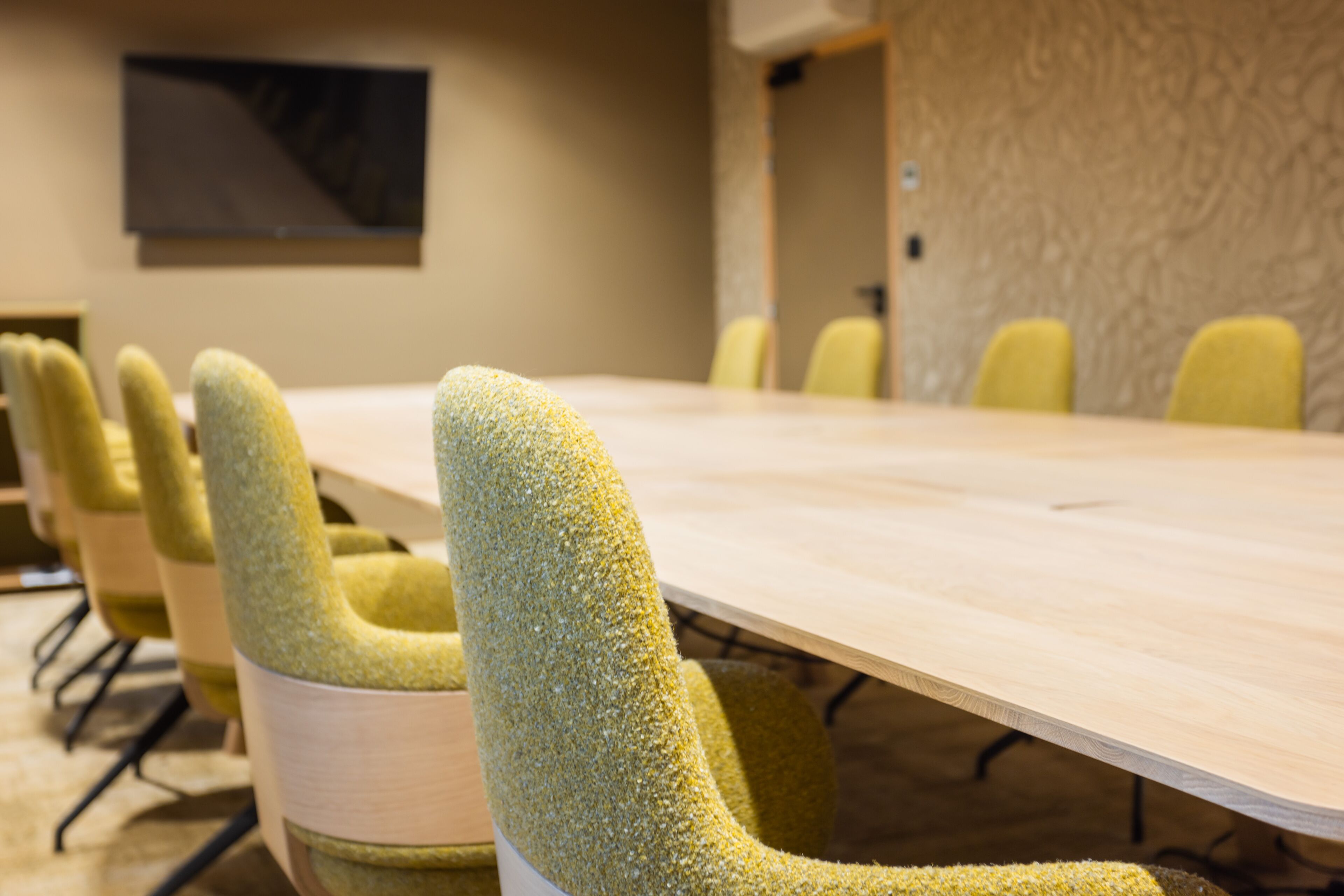 A conference room with a long table and several chairs.