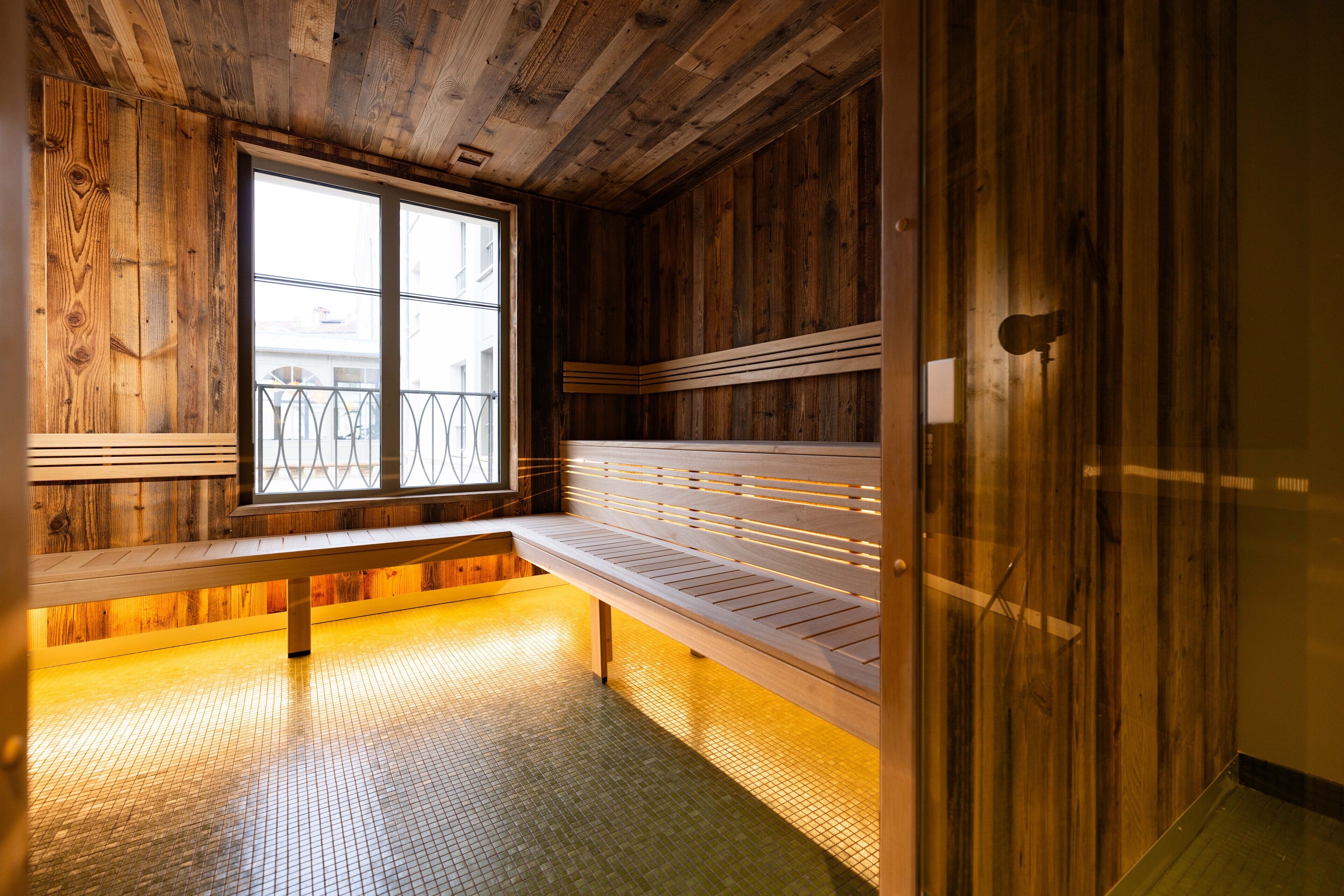 Un interior de madera con un banco y un ventanal.