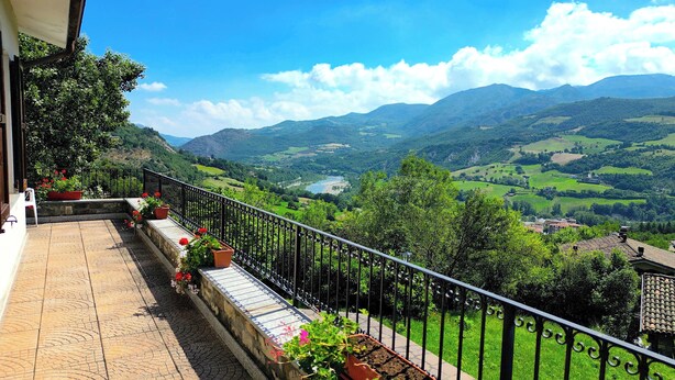 Un balcon avec vue sur une vallée et des montagnes.