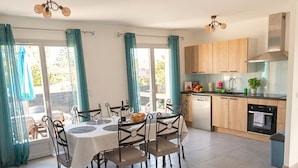 Een moderne keuken met houten kastjes, een vaatwasser en een fornuis.