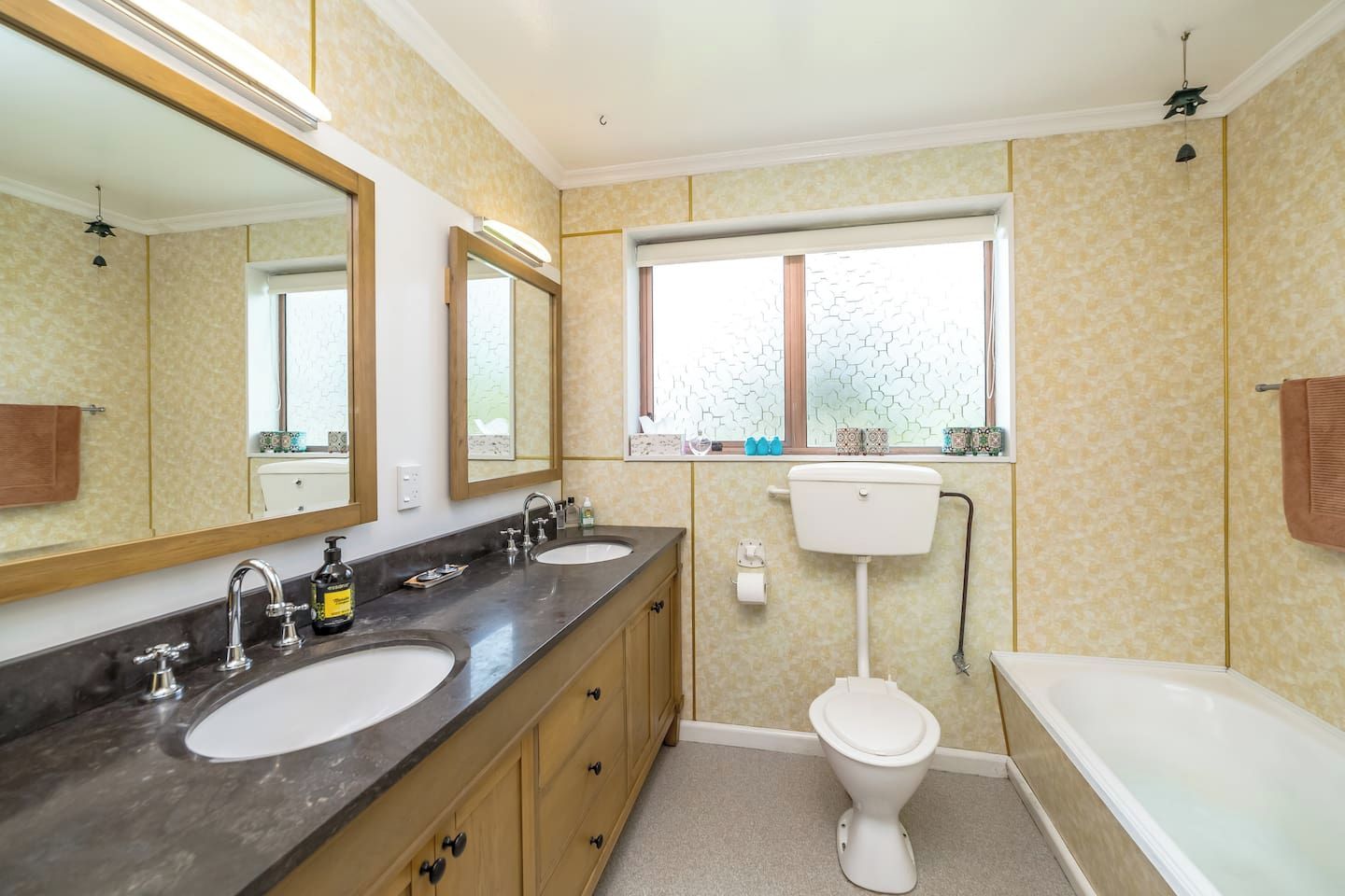 A bathroom with two sinks, a toilet, and a bathtub.