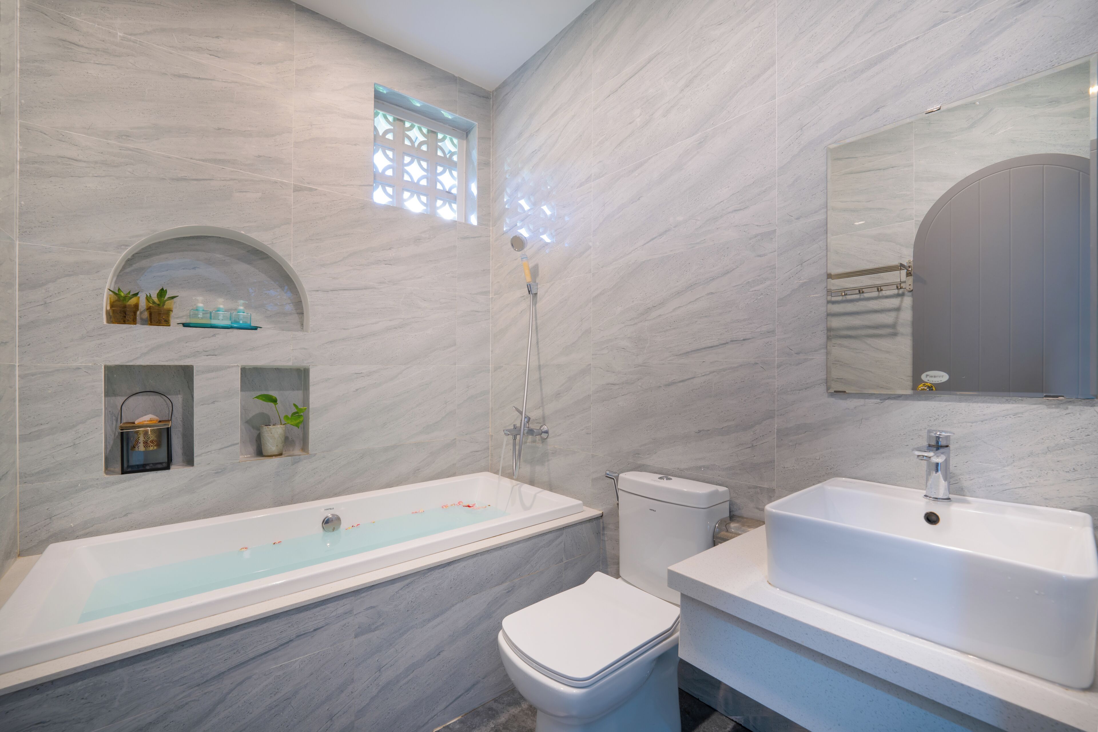Une salle de bain moderne avec une baignoire sur pieds, des toilettes et un lavabo.