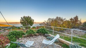 A hammock chair and another chair on a pebbled deck with a view of the sea and hills. - 1 bedroom gorgeous apartment in Gondolici (Gondolici)