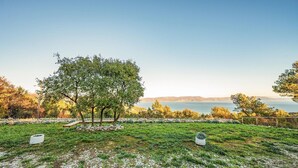A grassy area with a stone wall, a bench, and a large tree. - 1 bedroom gorgeous apartment in Gondolici (Gondolici)