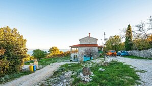 A stone house with a red-tiled roof, a small porch, and a view of the sea. There are two cars parked nearby. - 1 bedroom gorgeous apartment in Gondolici (Gondolici)