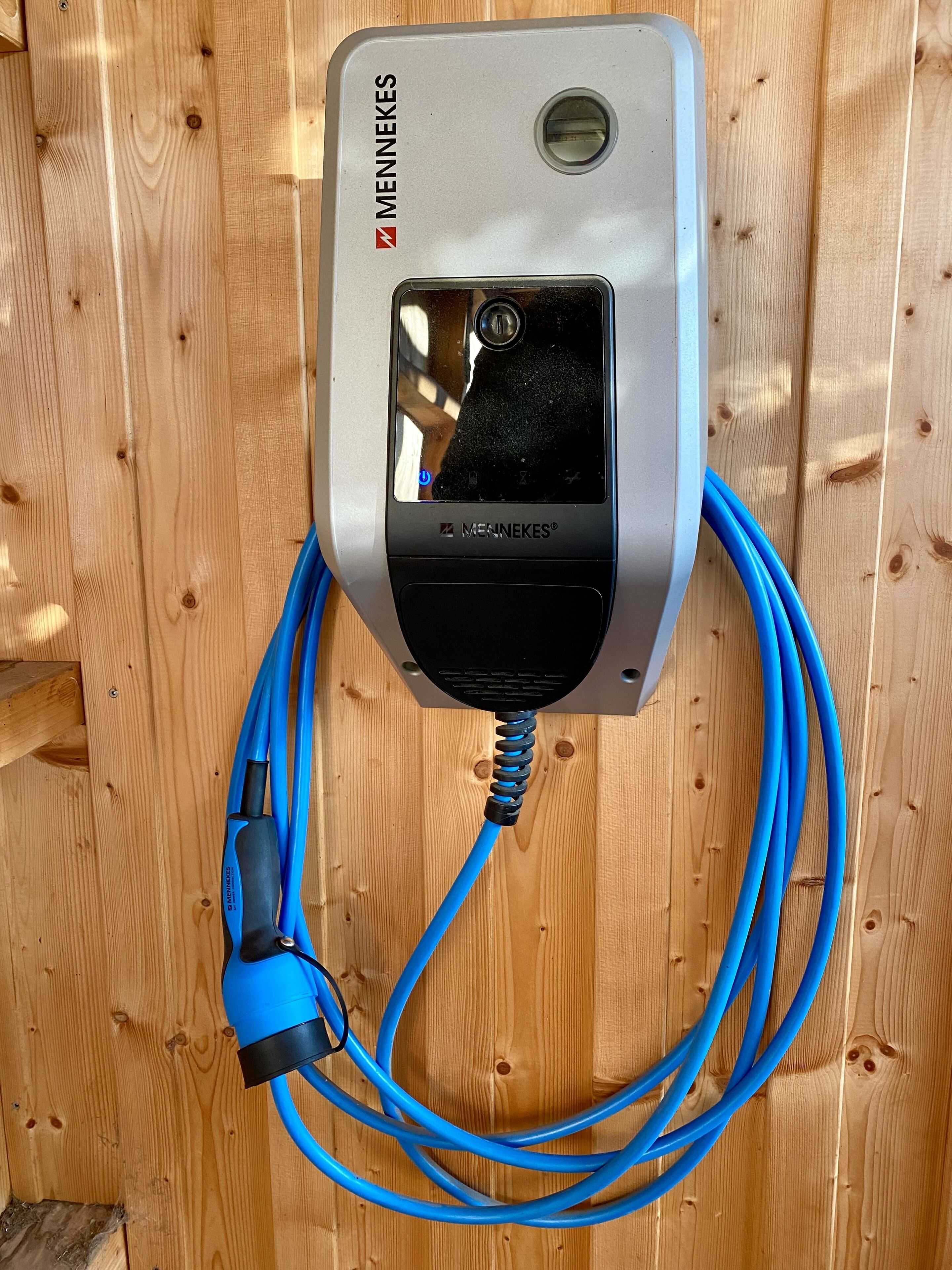 Een apparaat met een blauwe kabel, bevestigd op een houten oppervlak.
