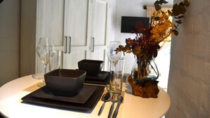 A dining table set with a bowl, cutlery, and a vase with dried flowers. - Private Studio with Kitchenette including Breakfast (Cape Town)