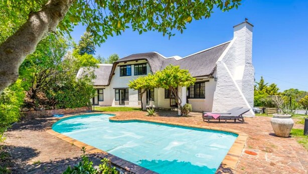 A house with a swimming pool, a stone exterior, and a garden. - Private Studio with Kitchenette including Breakfast (Cape Town)