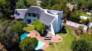 A modern house with a unique architectural design, a swimming pool, and a well-maintained garden. - Private Studio with Kitchenette including Breakfast (Cape Town)