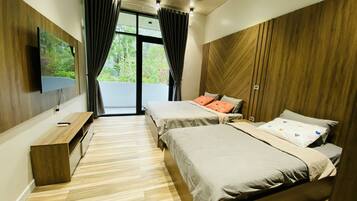 A modern bedroom with two beds, a TV, and a balcony with curtains.