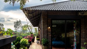 A brick building with a tiled roof and a glass door entrance. - TICO VILLA TAM DAO (Tam Dao)