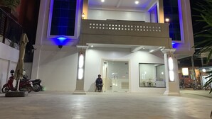Een hotel met meerdere verdiepingen, met een modern ontwerp, voorzien van balkons en een ruime entree.