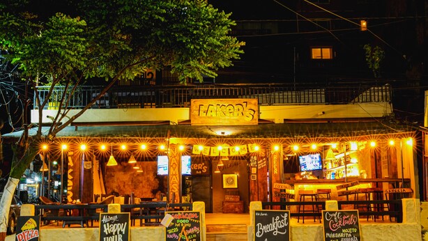 A restaurant with outdoor seating, a sign reading "LAKER'S", and various menu boards advertising food and drinks. - Lakers Bed and Breakfast (Pokhara)