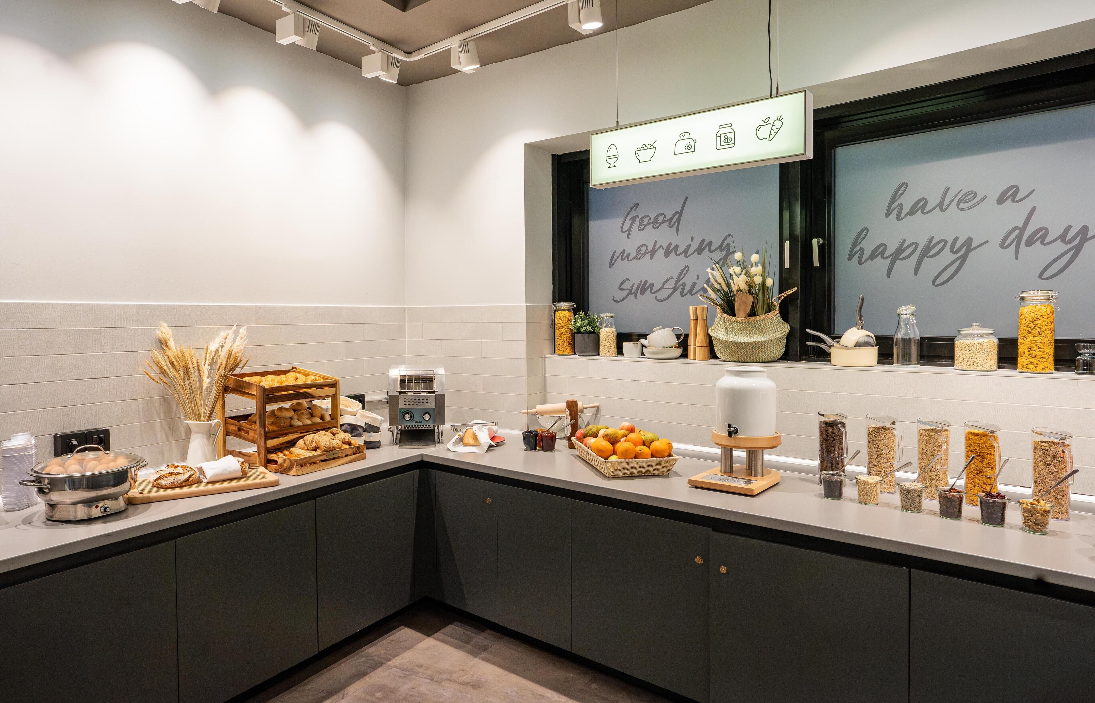 Une cuisine moderne avec un bar pour prendre le petit-déjeuner, divers produits alimentaires et un message motivant affiché sur le mur.