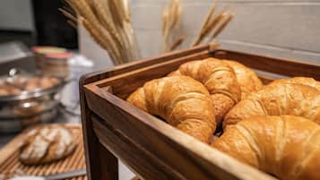 Una bandeja de madera con varios croissants dorados.