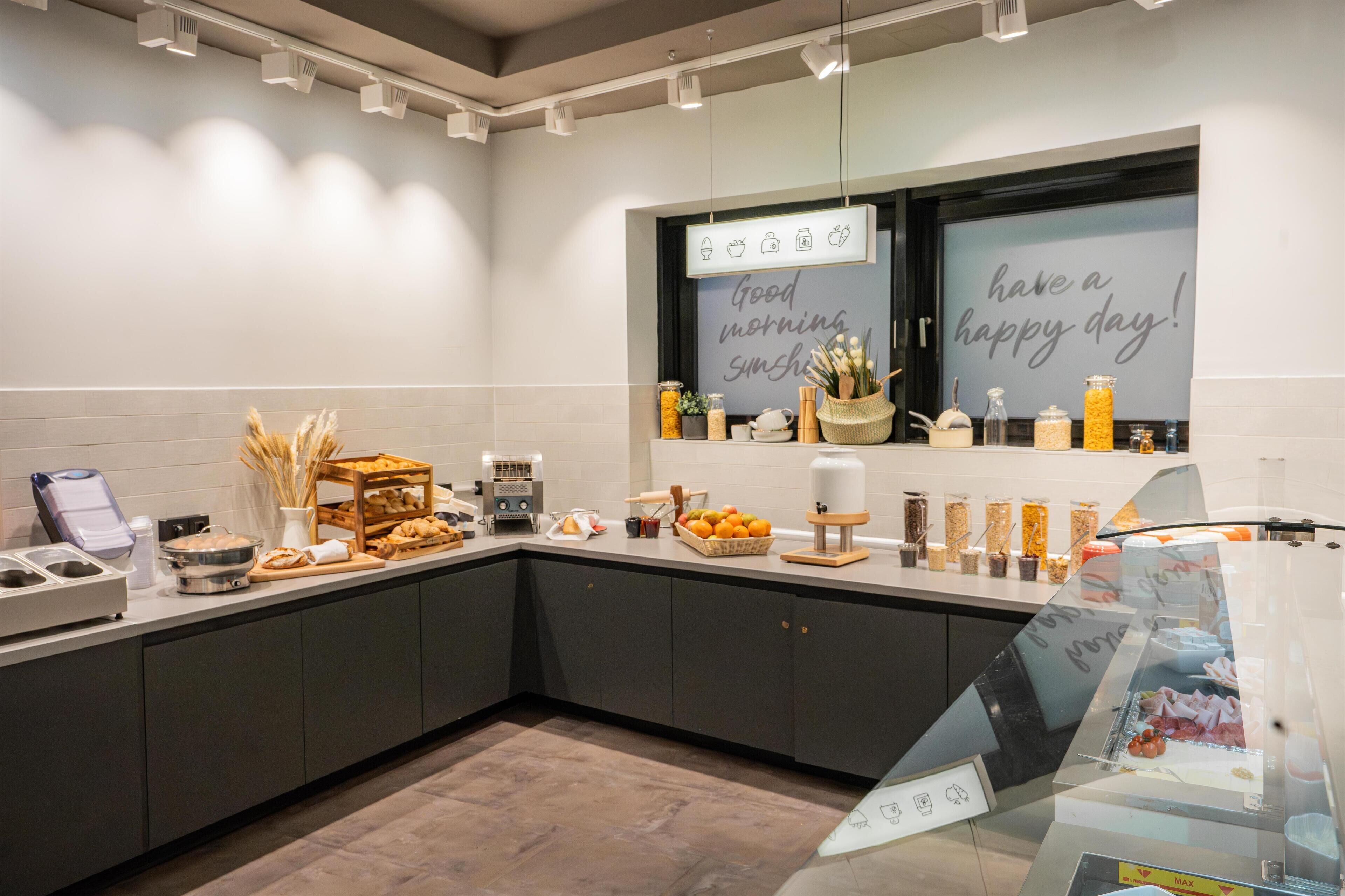 A modern kitchen with a breakfast bar, equipped with various food items and appliances.