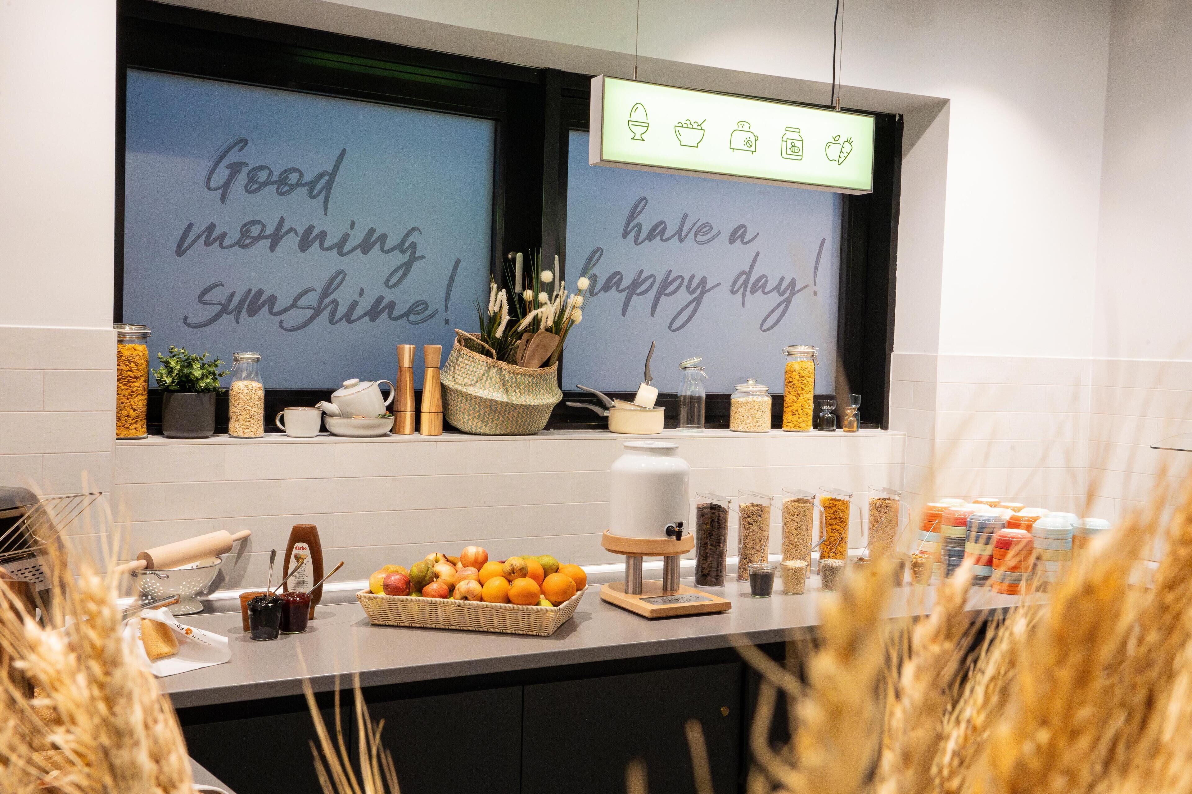 A kitchen counter with a variety of food items, kitchen utensils, and a coffee machine.